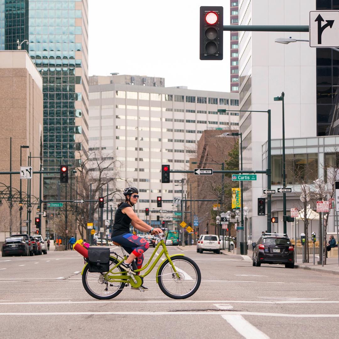 Person commuting on bike in city. Photo by Instagram user @peopleforbikes