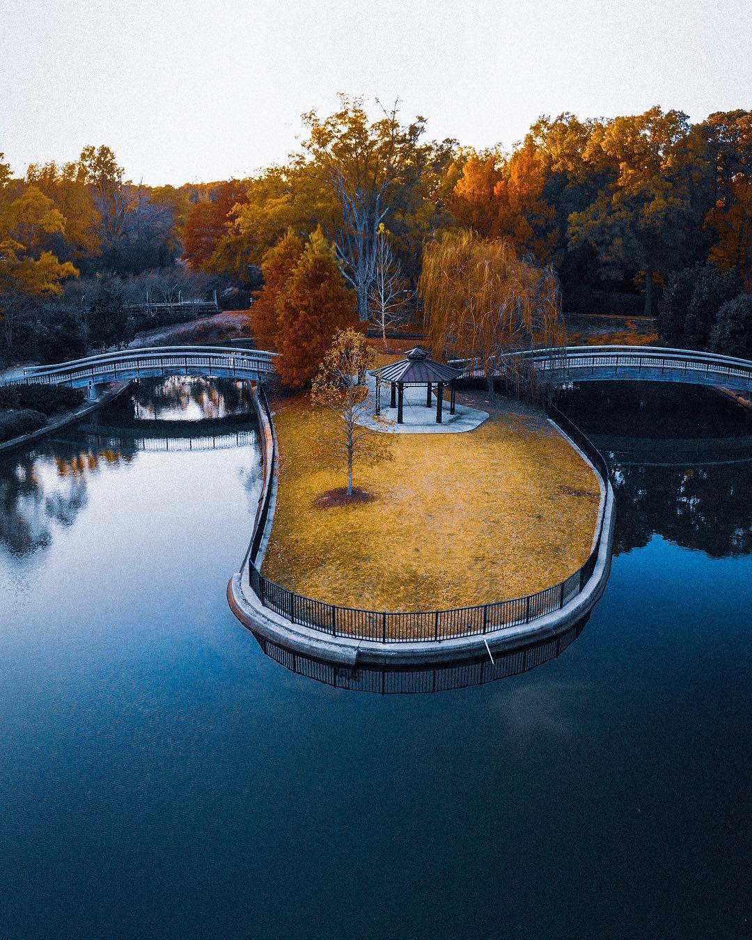 Overhead view of pond and greenspace with bridges and shelter at Pullen. Park Photo by Instagram user @rawsta_photo