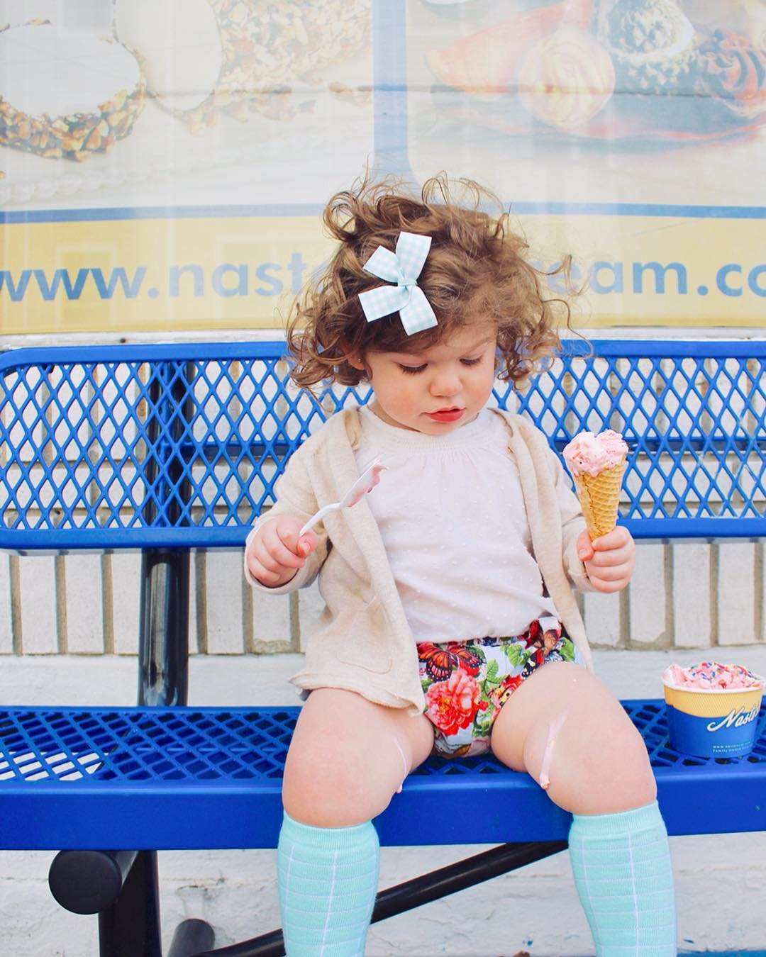 Young girl looking at ice cream dripping on her leg while holding an ice cream cone and spoon. Photo by Instagram user @kathleen_templeton