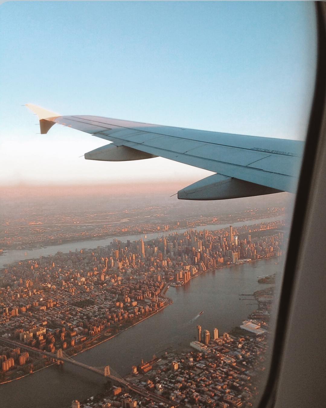 View of Newark and a plane's wing from inside a plane. Photo by Instagram user @madametamtaaam