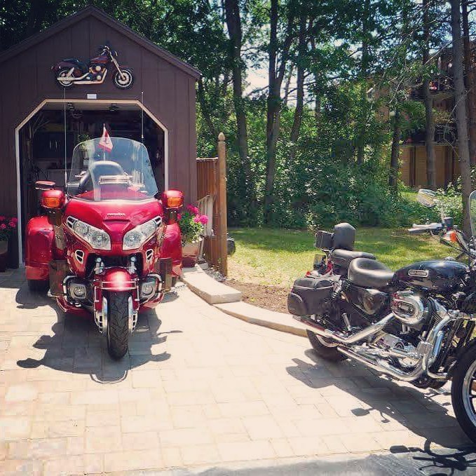 Red motorcycle being pulled out of a motorcycle shed photo by Instagram photo @northcountrysheds