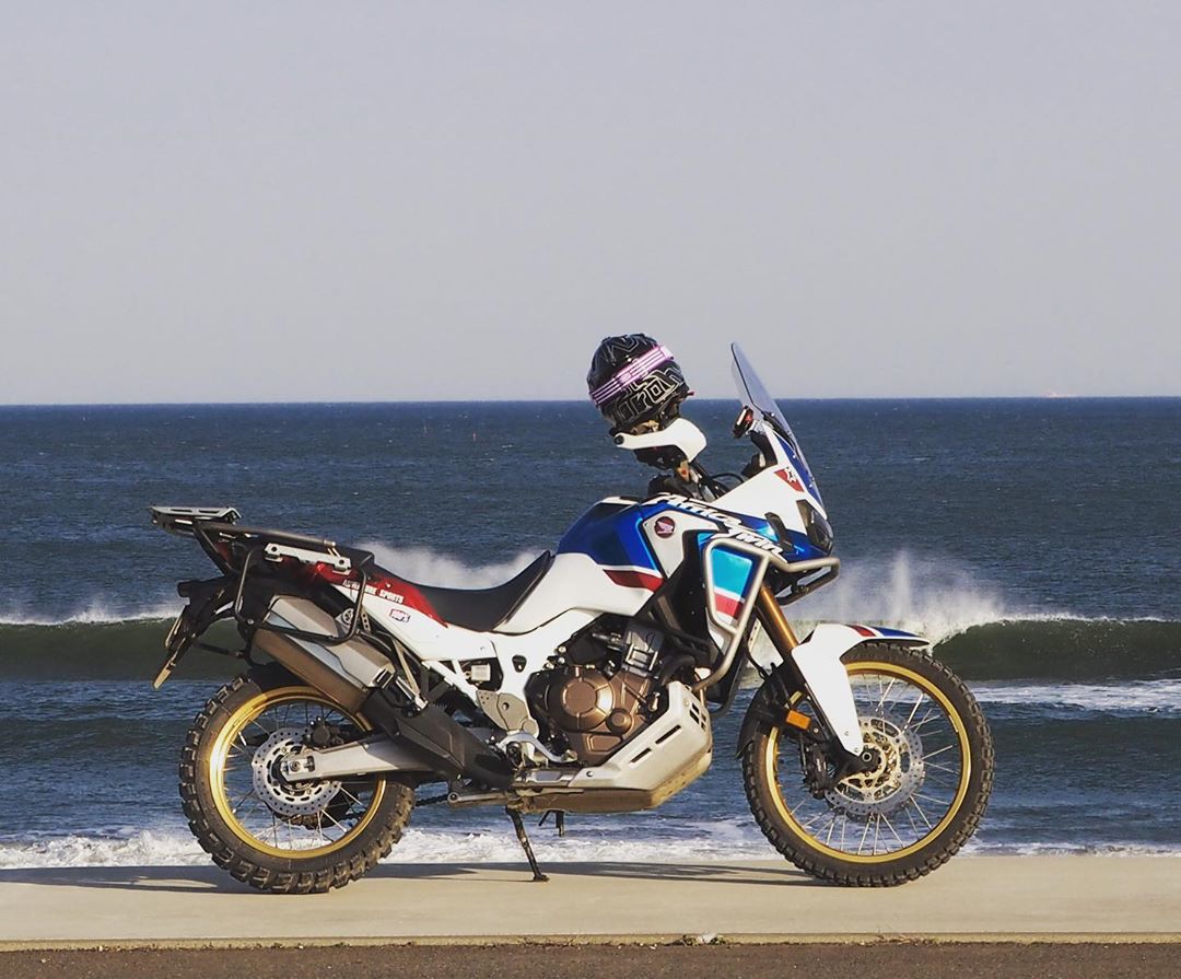 off-road bike with helmet resting on it in front of ocean photo by Instagram user @aoserow