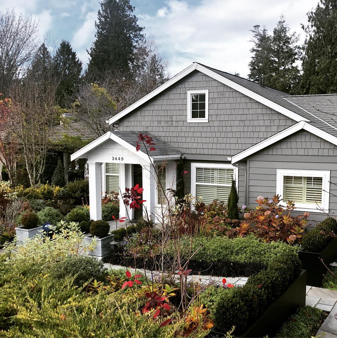 Grey Cape Cod style home with white pillars in Magnolia, Seattle. Photo by Instagram user @urbanjenni