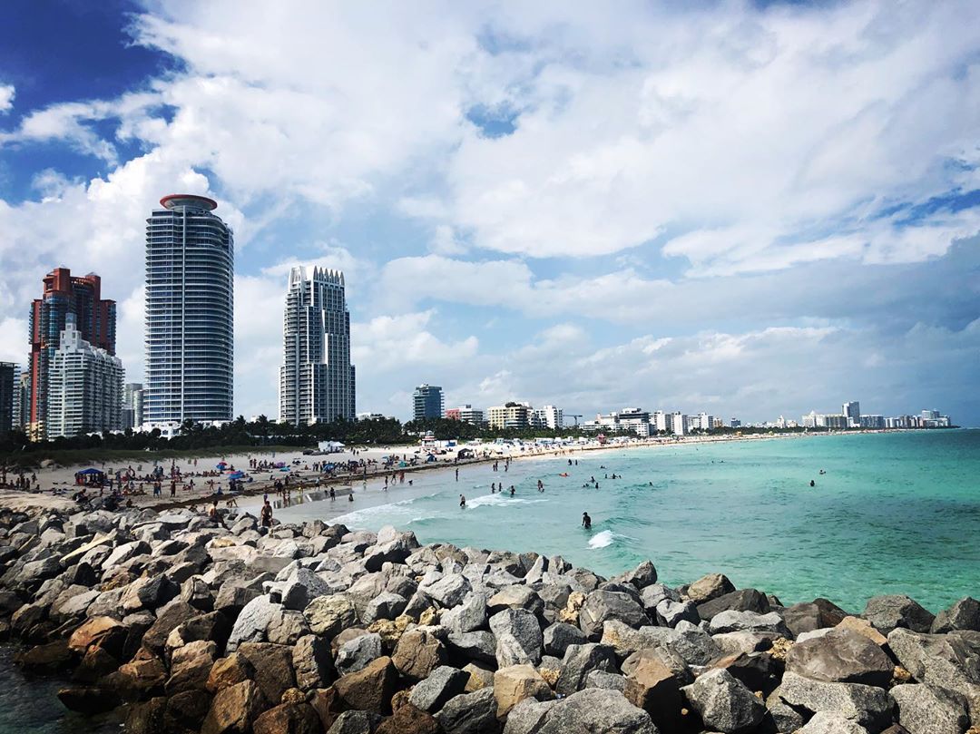 Tall buildings next to the ocean in Miami. Photo by Instagram user @jimmypolitan
