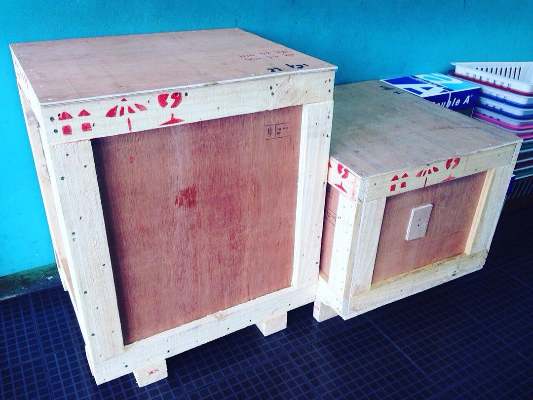 Wooden crates next to blue wall. Photo by Instagram user @dynamicaircargo