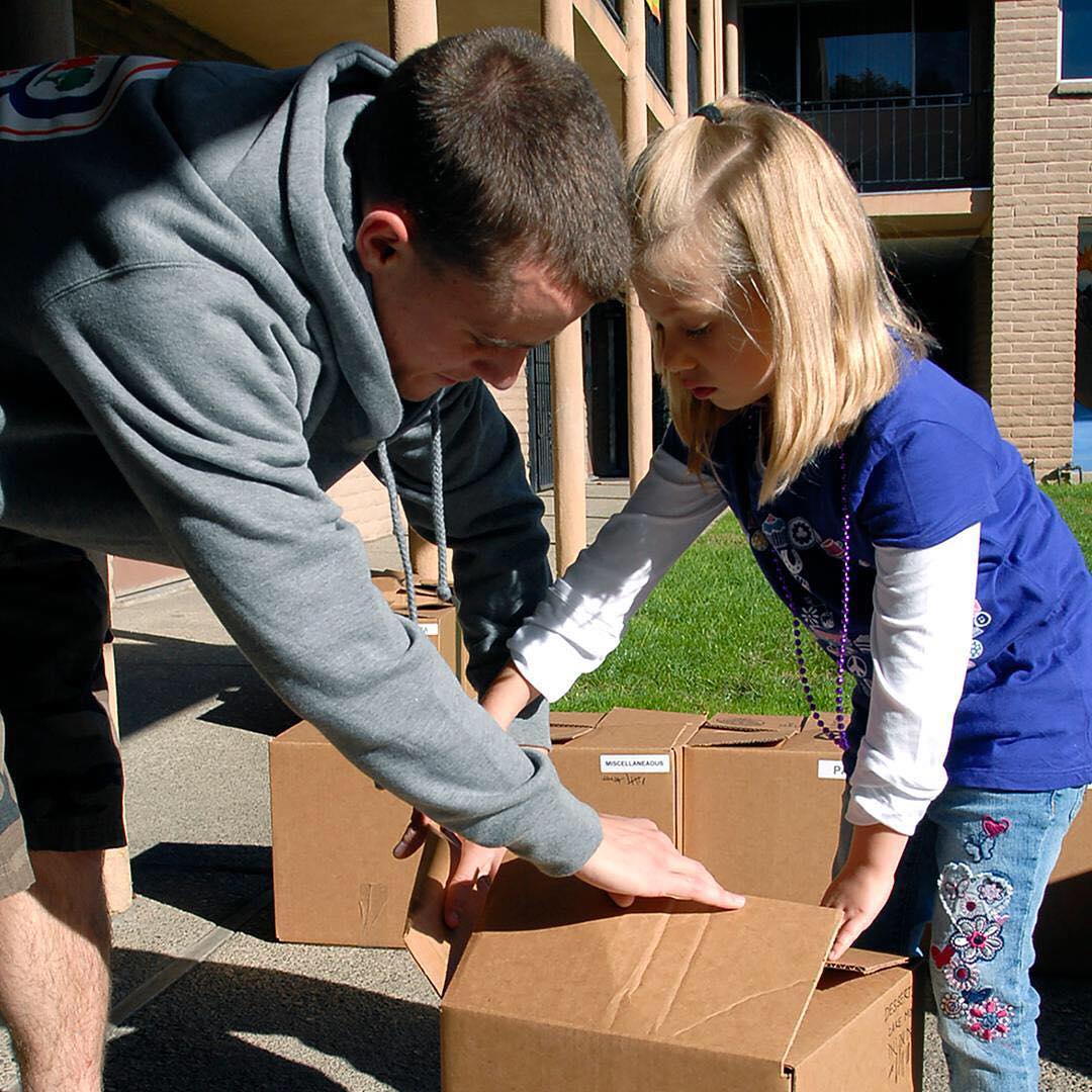 Dad and kid packing a box together. Photo by Instagram user @military1source