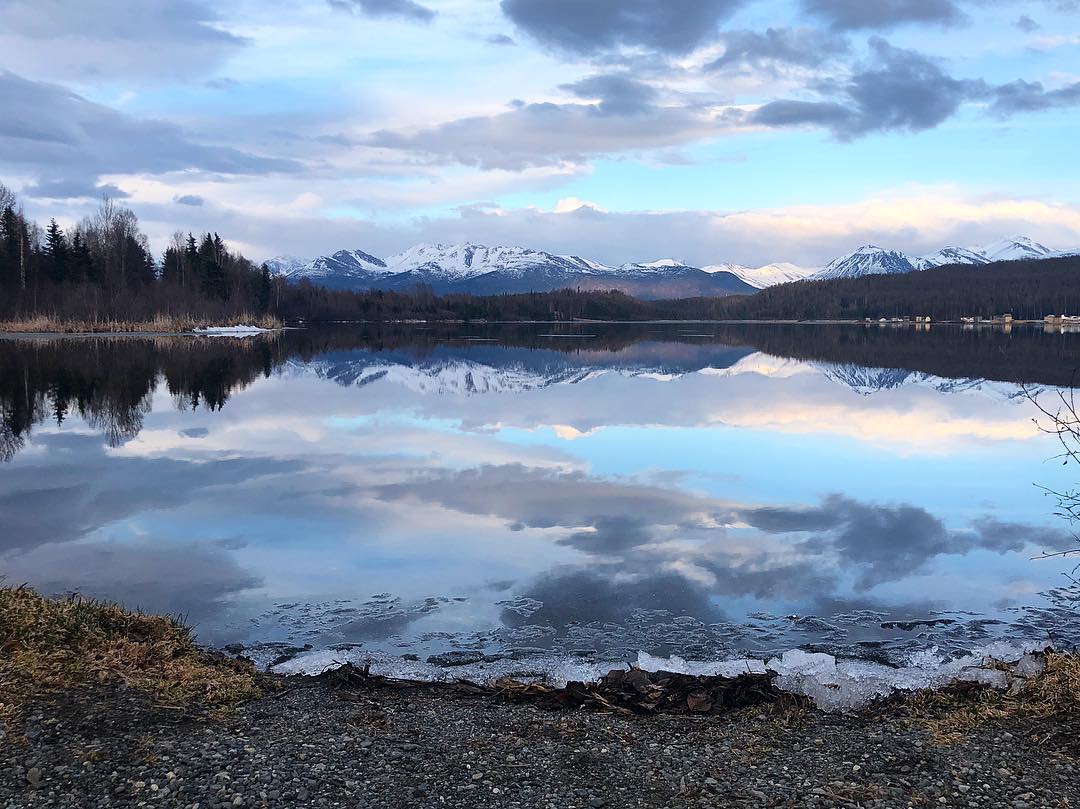 Lake and mountains under purple sky in Anchorage, AK. Photo by Instagram user @1000swordsbystelly