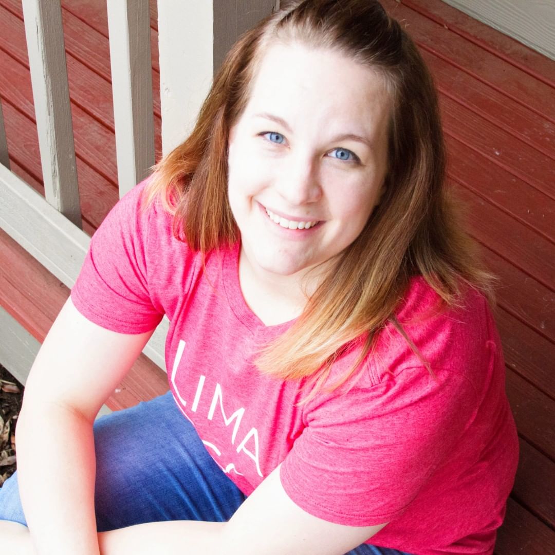 Blonde woman sitting on a red porch. Photo by Instagram user @mrsnavymama