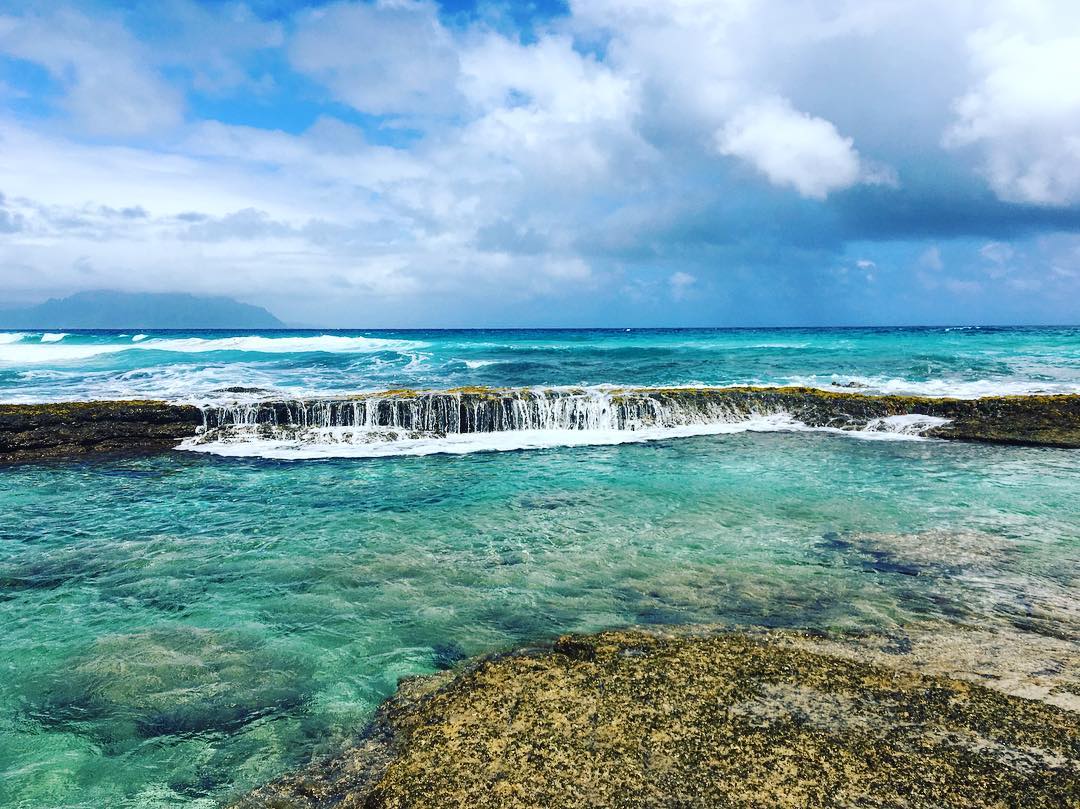 Crystal blue water fall in the ocean in Hawaii. Photo by Instagram user @hyperheather