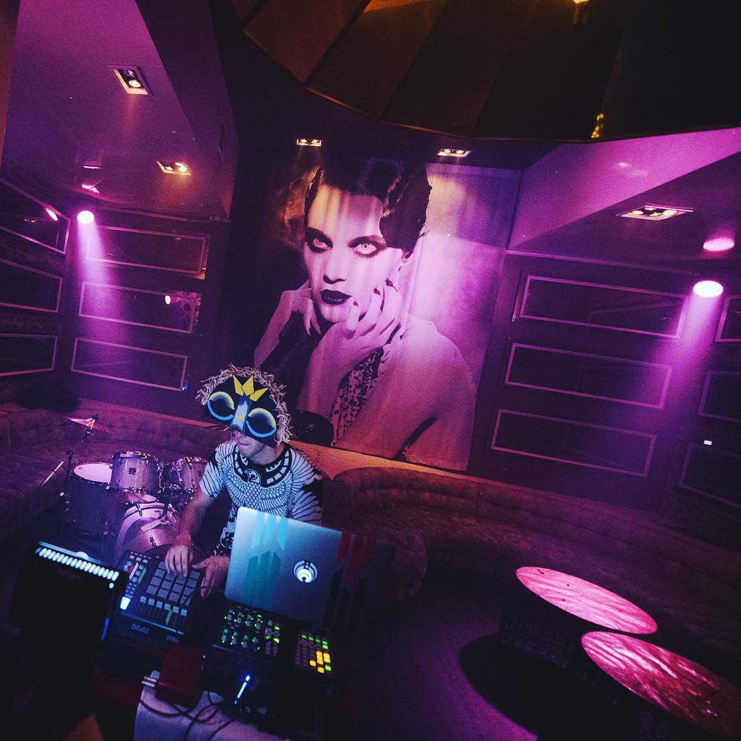 Man DJing in a club with purple lights. Photo by Instagram user @phantomairship