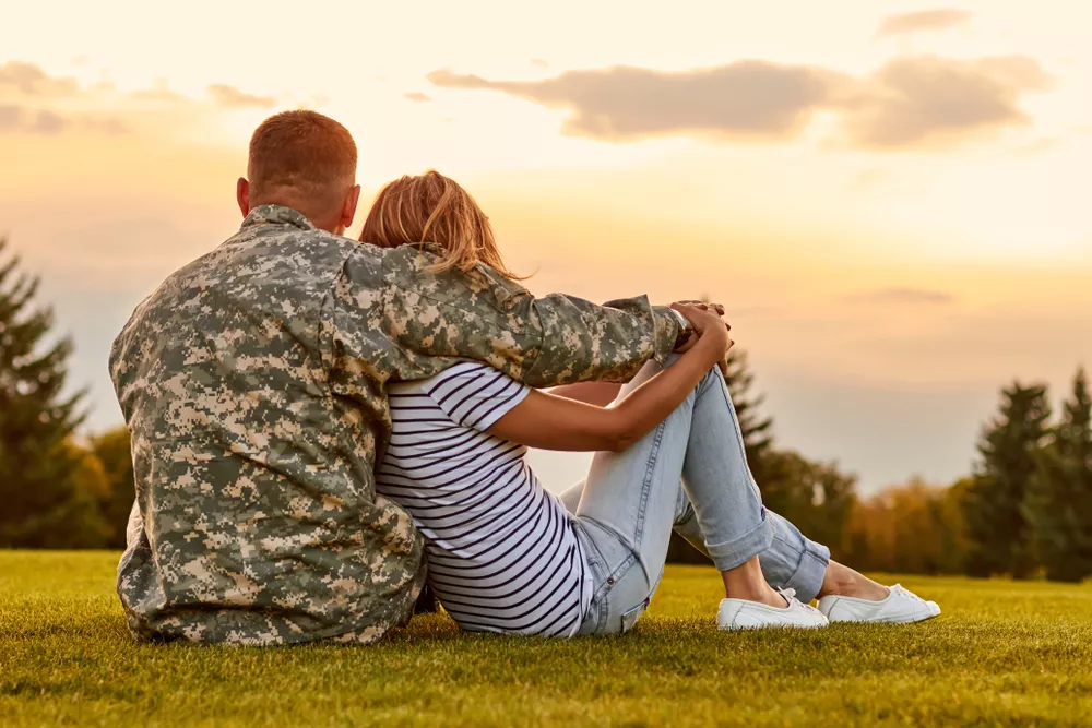 Military husband hugging his wife as the sun sets