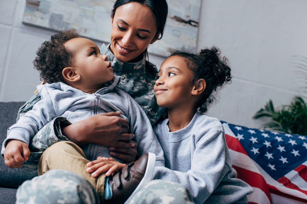 Military woman and her two kids hugging.