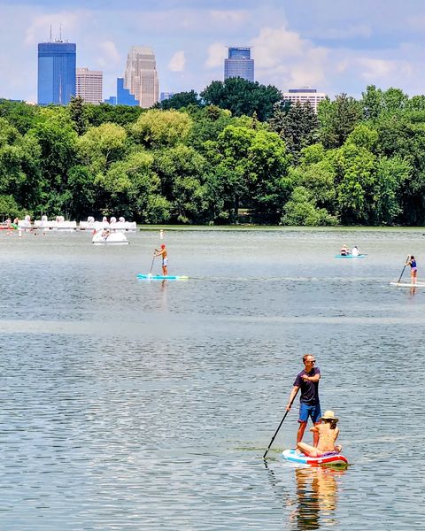 People paddleboarding on Lake Nokomis on a sunny day. Photo by Instagram user @itsallworthseeing.