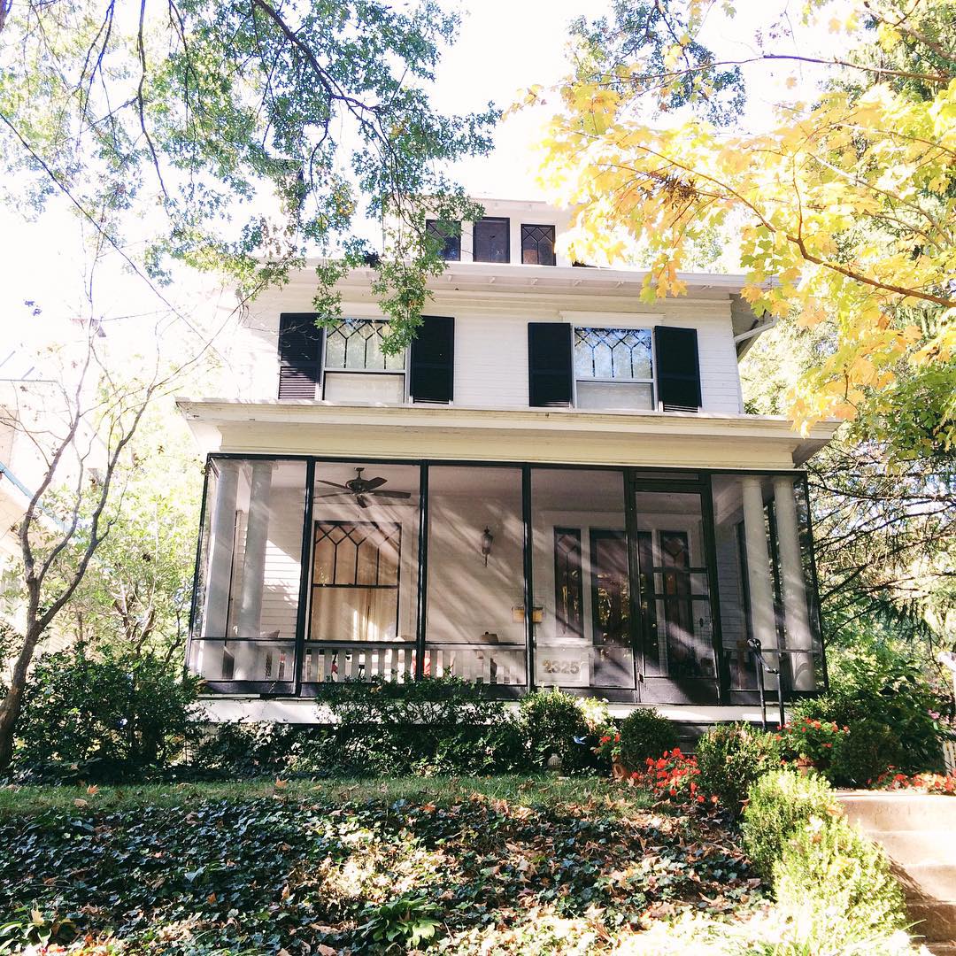 Two story white house with black trim and a sun room in Bonnycastle, Louisville. Photo by Instagram user @housesoflouisville