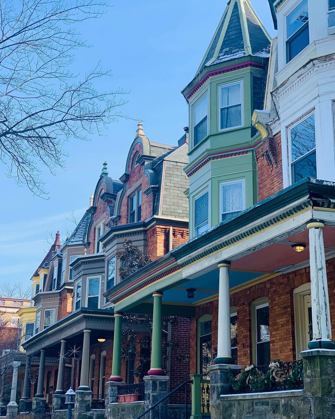 Green and white and brick rowhouses in Cedar Park, Philadelphia. Photo by Instagram user @rachelharvs