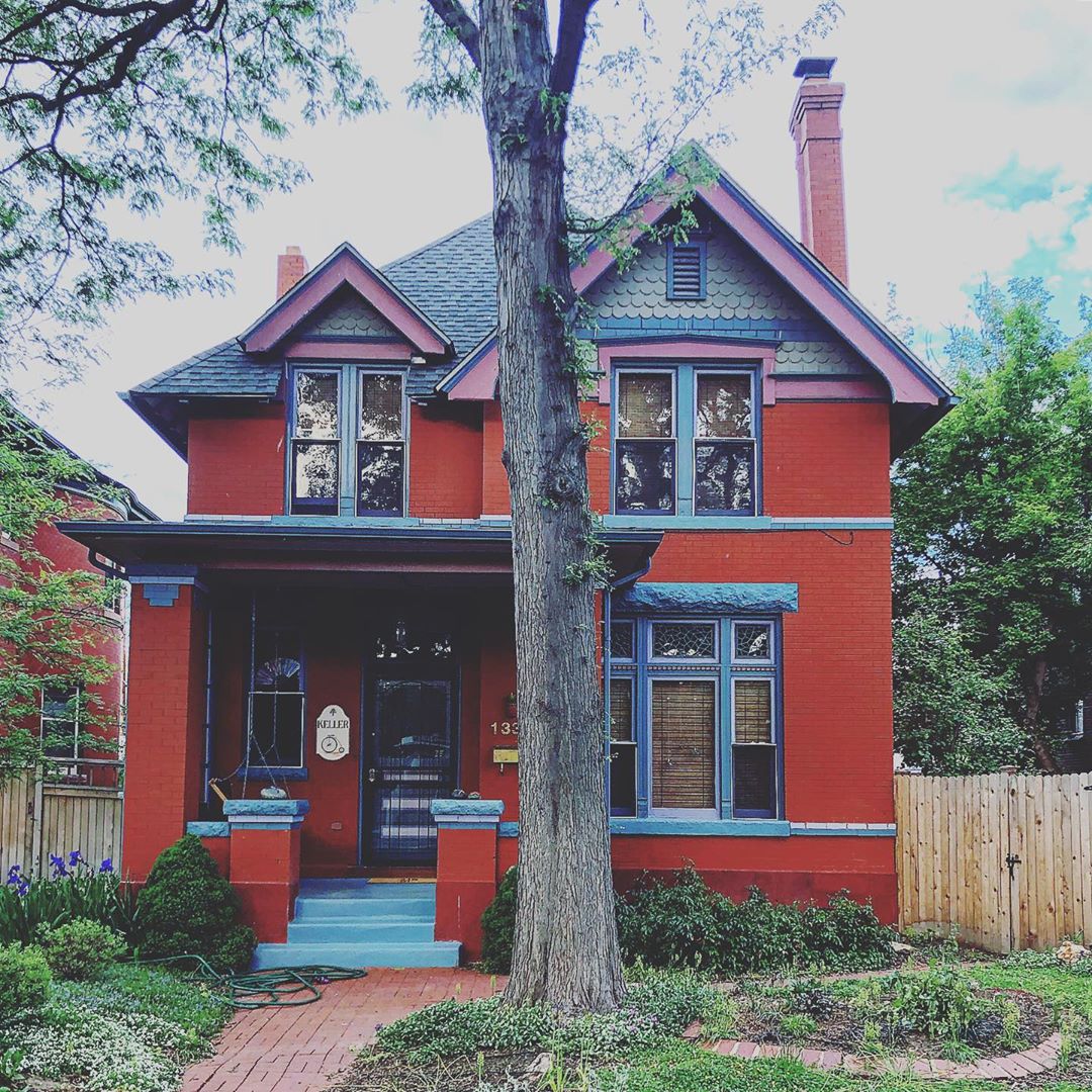 Two story home painted red with blue trim in Congress Park, Denver. Photo by Instagram user @grantrstevens
