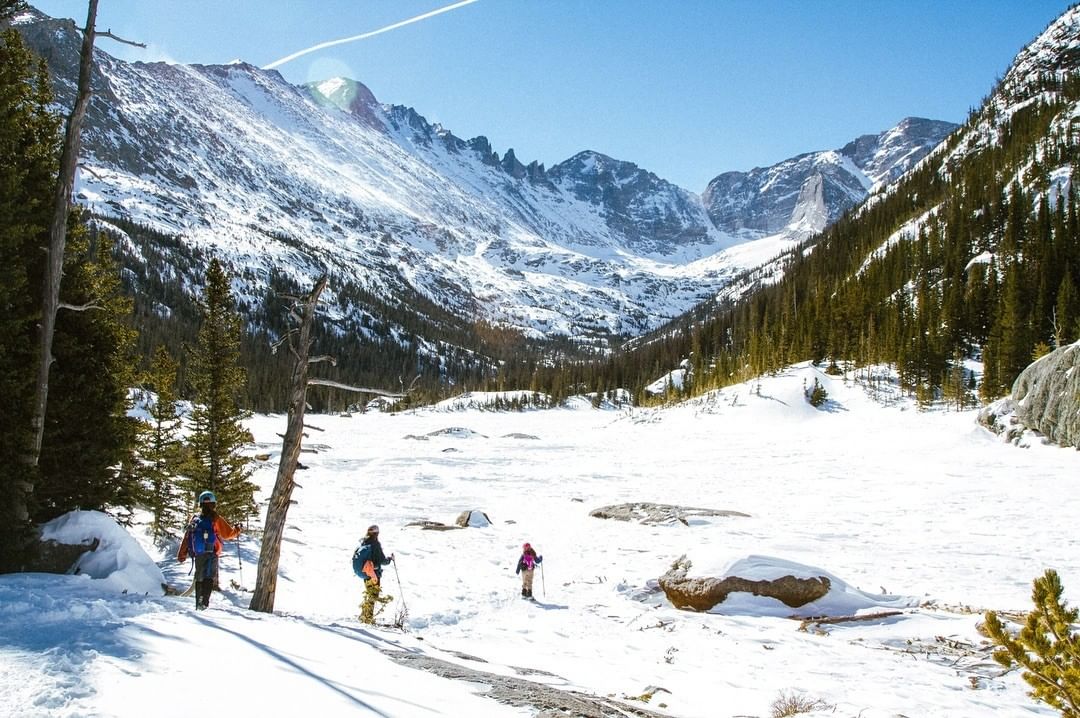 A group of people cross country skiing through the Rock Mountains. Photo by Instagram user @aroundaround