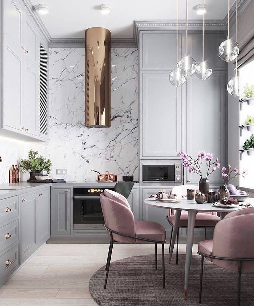Kitchen with light gray cabinets and velvet pink chair. Photo by Instagram user @marieburgos.design