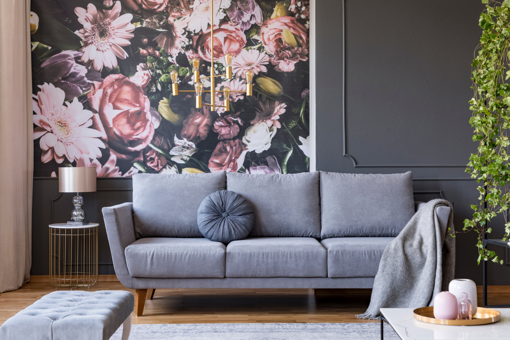 Dark gray living room with a light gray couch and pink floral accent wall