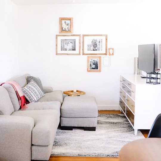 White living with a gray comfy couch. Photo by Instagram user @thelaminimalist