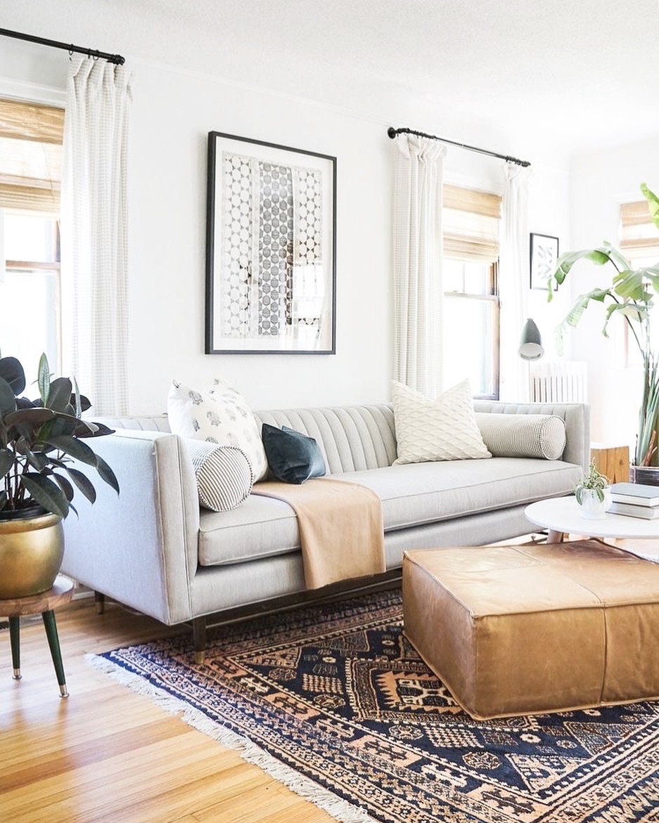 White living room with big windows and a gray couch. Photo by Instagram user @christalowryrealestate