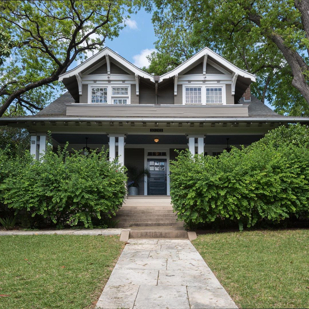 Two-story dark gray house with white trim in North University, Austin. Photo by Instagram user @edgeofthelight