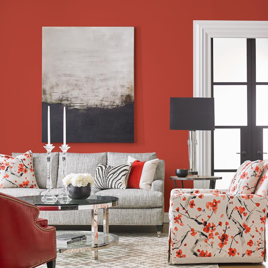 Living room painted red with gray and red decor. Photo by Instagram user @cabothouserhodeisland