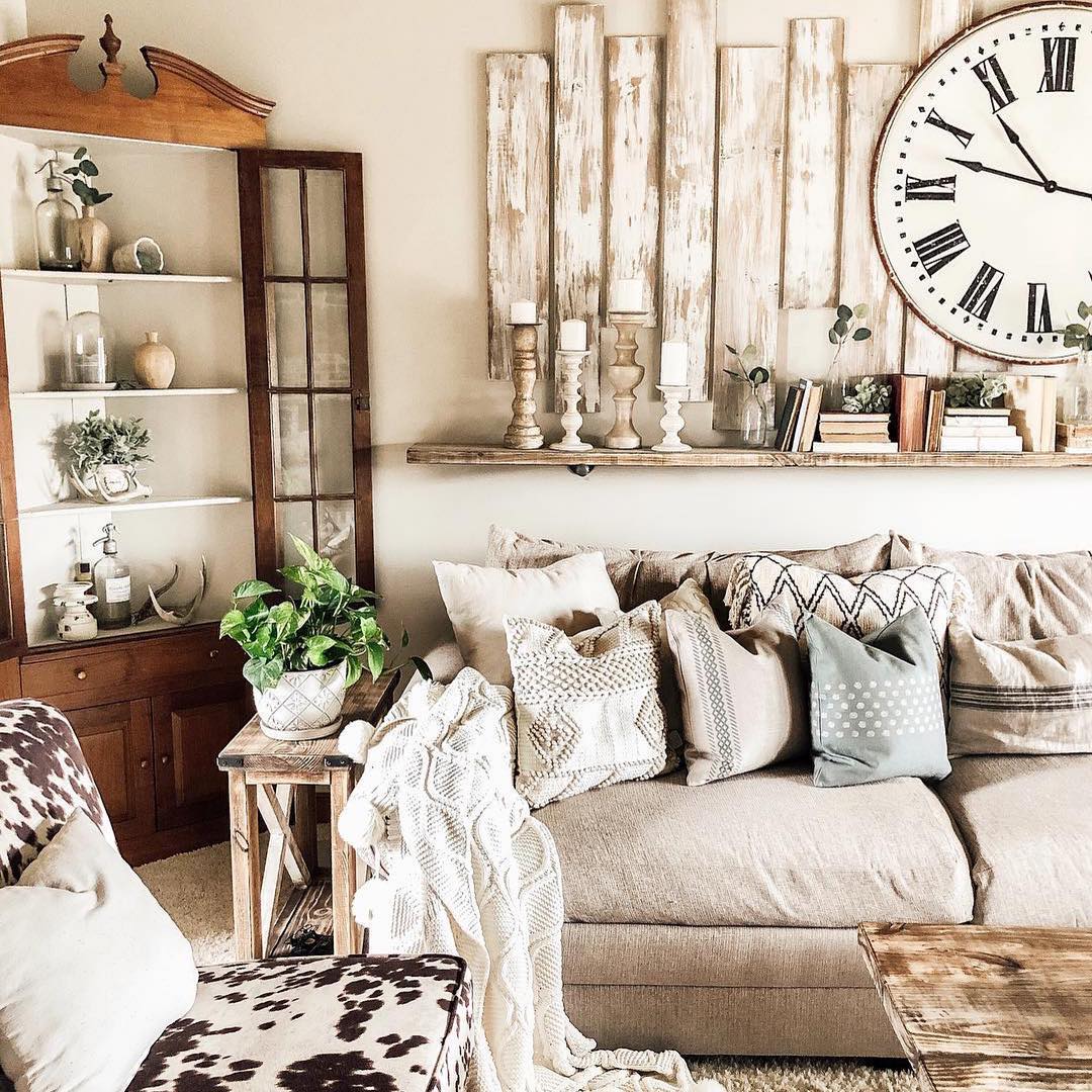 Living in Rustic style with gray couch and patterned pillows with worn wood on the wall. Photo by Instagram user @vintagemarketdayscntrlnr