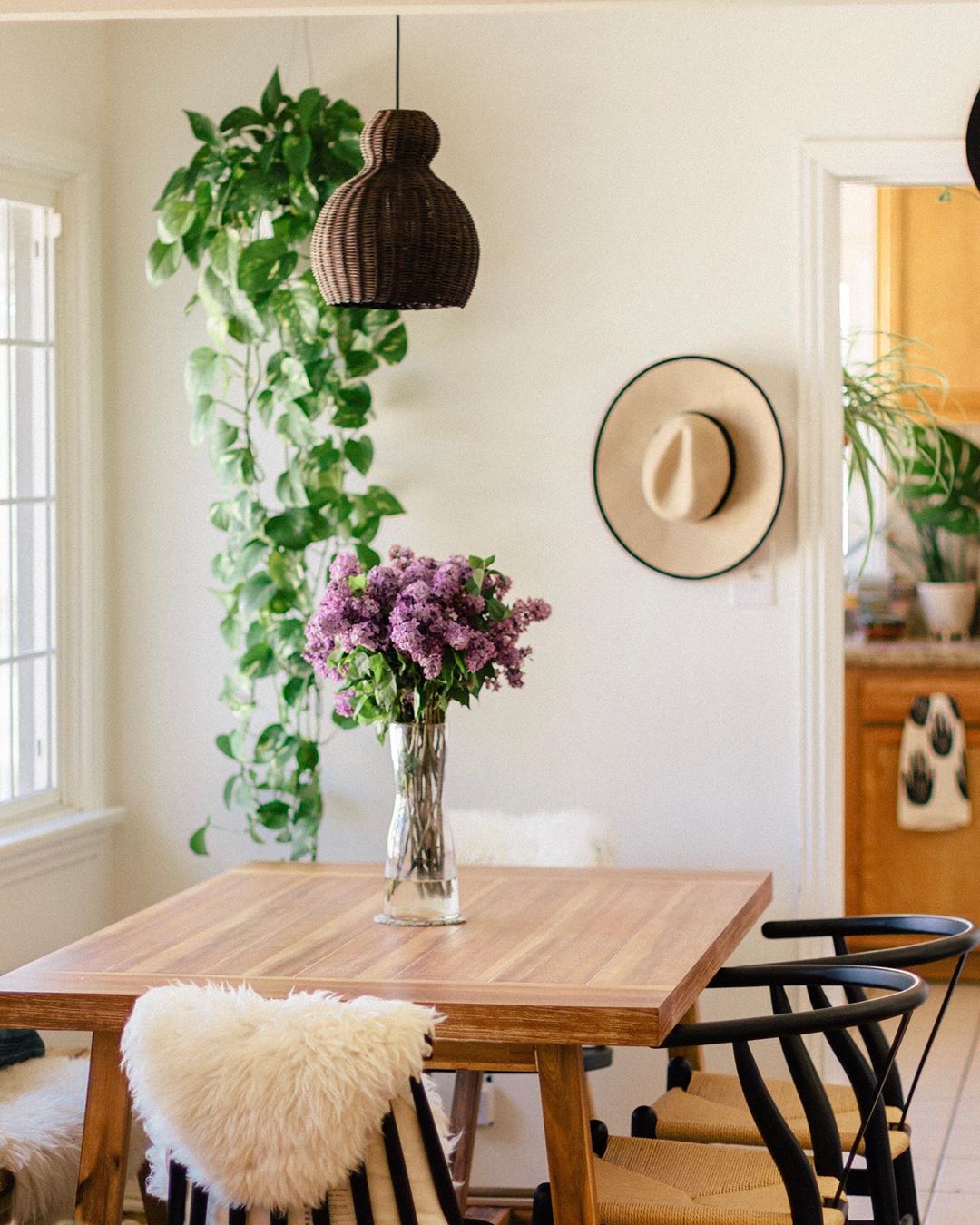 Dining room with wood table and vase of purple flowers on it. Photo by Instagram user @saratoufali