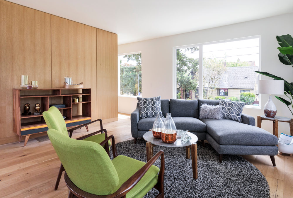 Living with wood floors and green chair and navy couch.