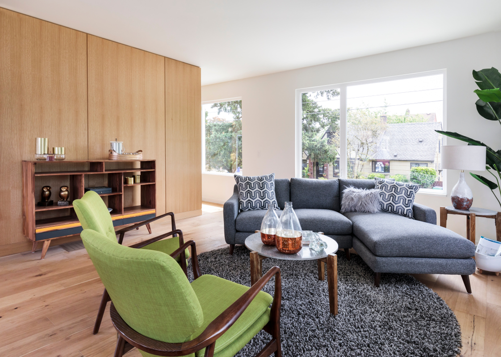 Living with wood floors and green chair and navy couch.