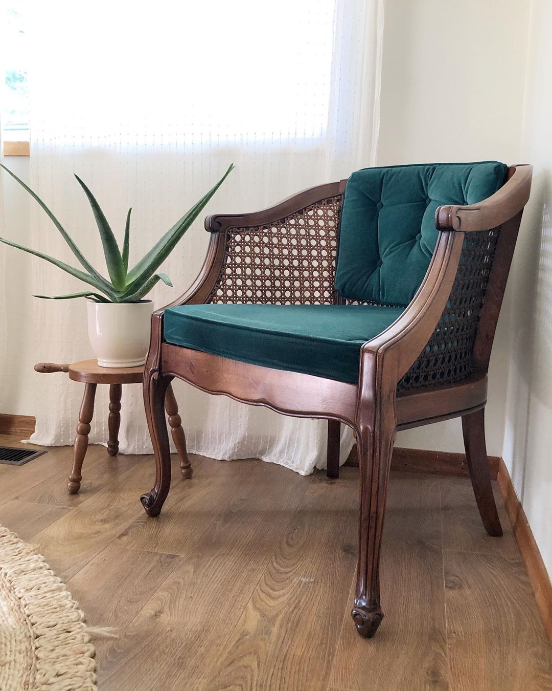 Green and brown vintage chair in the corner of a room. Photo by Instagram user @shoppe_eclectic