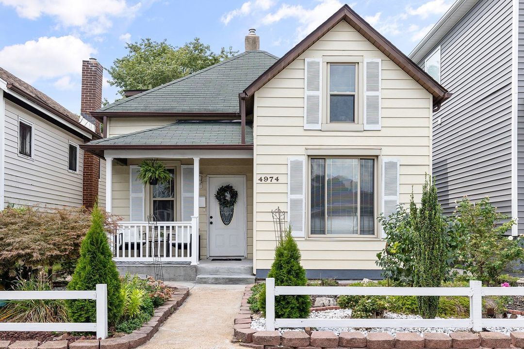 Cream-colored house in St. Louis with white shutters and a small front porch. Photo by Instagram user @lourealtygroup.