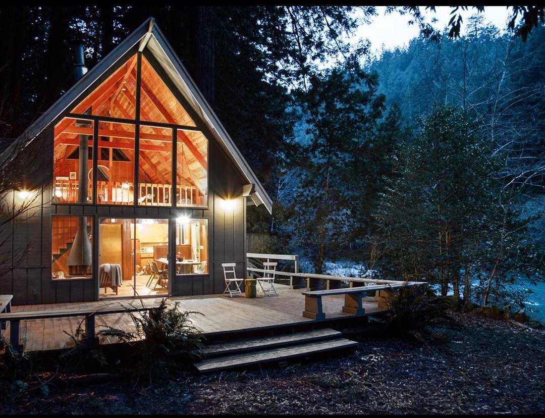 A-frame cabin in California at night. Photo by Instagram user @cozycabingetaways