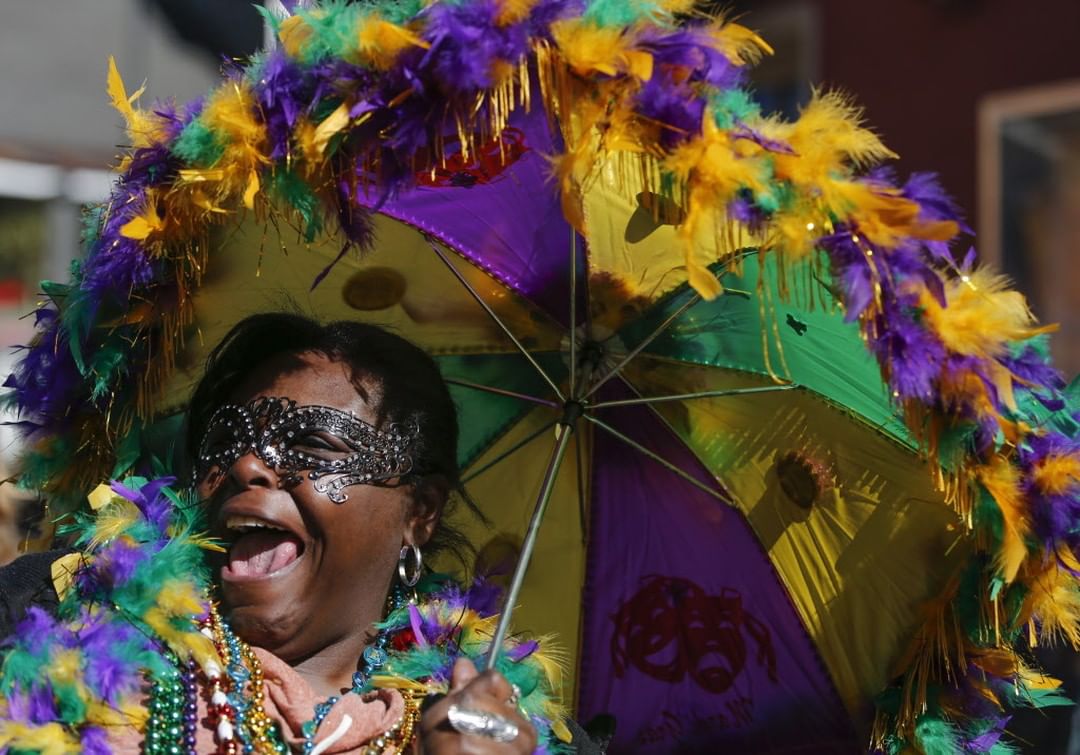 Woman wearing purple, green, and yellow for mardi gras in New Orleans. Photo by Instagram user @nolamardigras