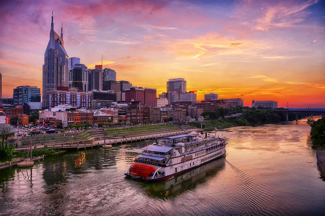 Sunset over skyscrapers and boat in the river in Nashville, TN. Photo by Instagram user @keno1947