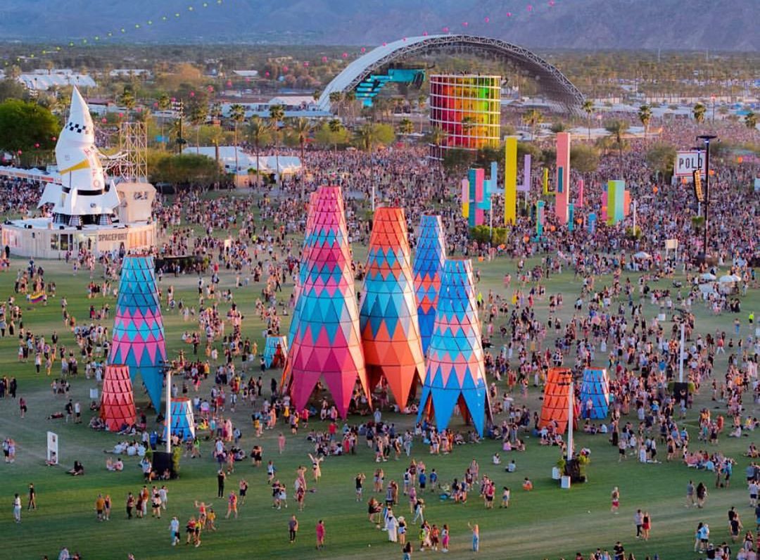 Tall colorful sculptures and music stages at Coachella festival. Photo by Instagram user @whiteowlaerial