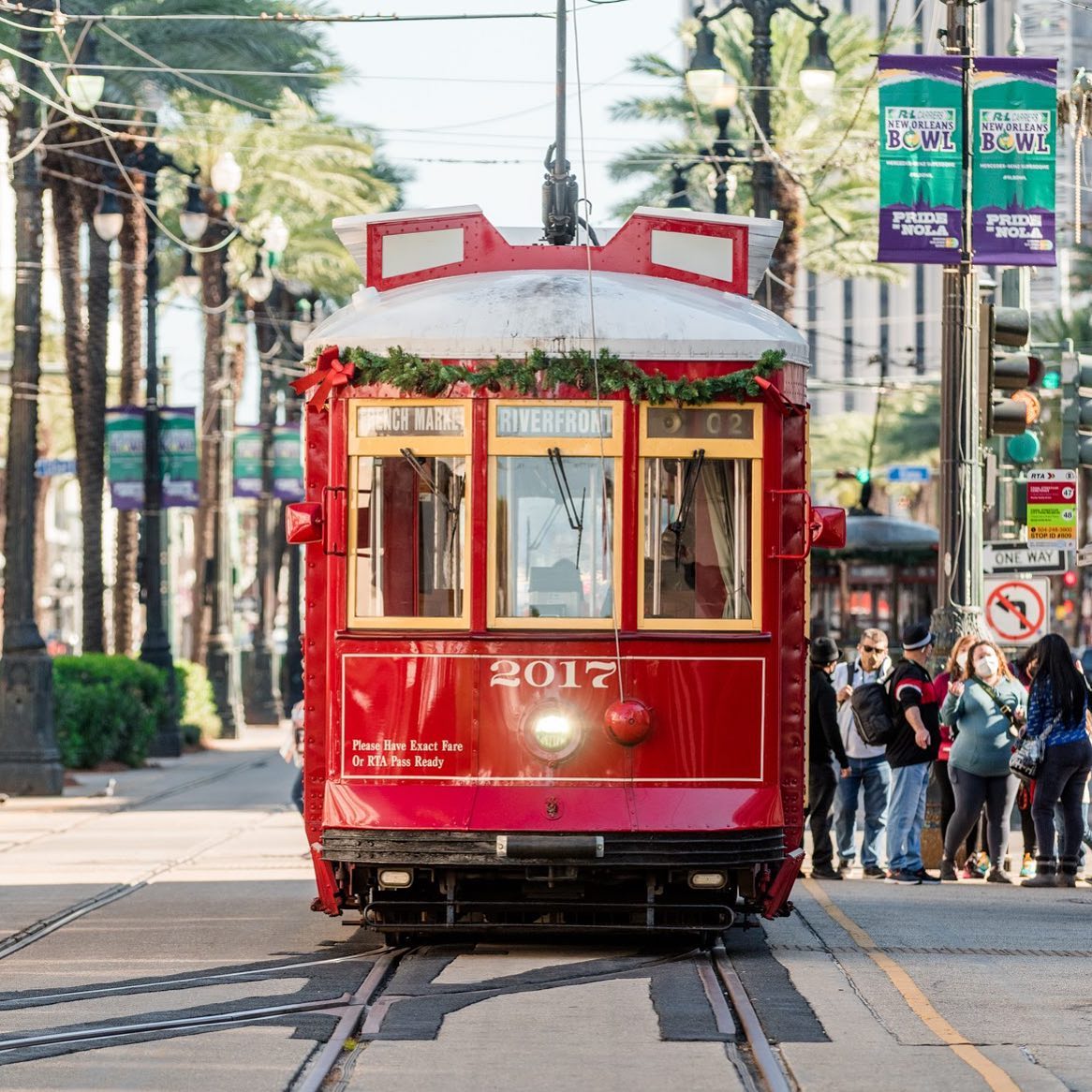 Red streetcar carrying passengers in New Orleans. Photo by Instagram user @410inthe504