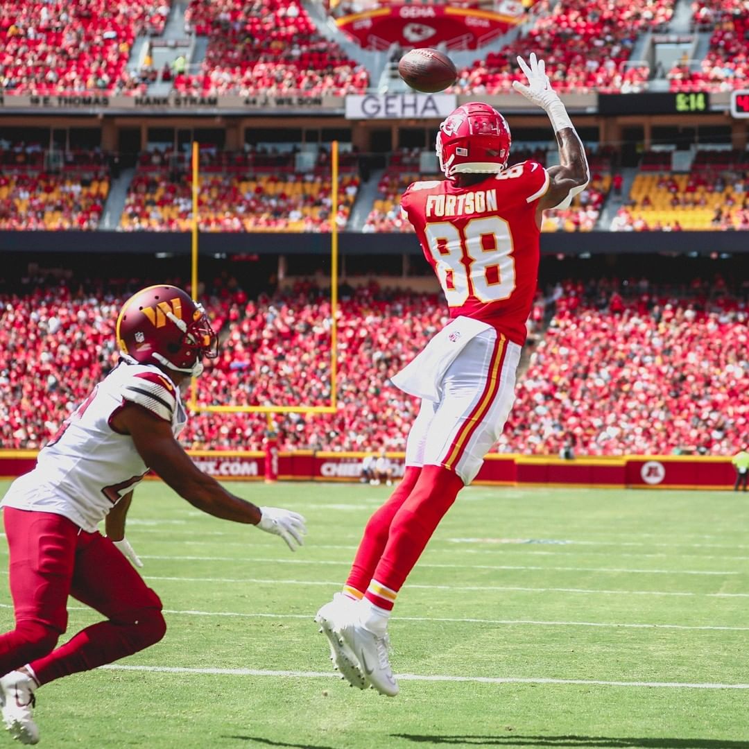 A Kansas City Chiefs football player about to catch a ball at Arrowhead Stadium while his deffender comes over to try to stop him. @chiefs 