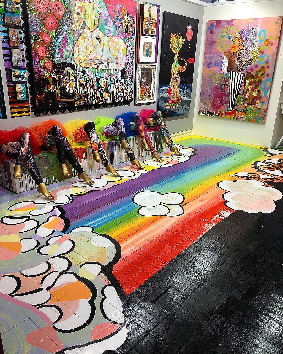 Room in an art museum with bright art on the wall and rainbows on the floor. Photo by Instagram user @omiexperience