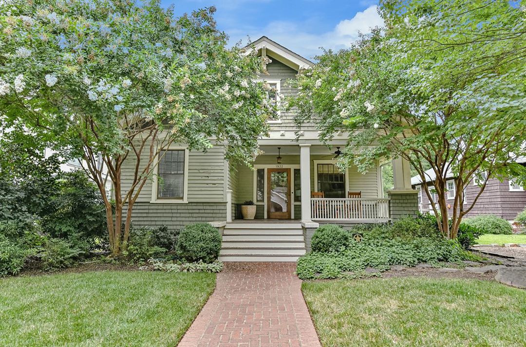 Two story light green house with white trim and big trees in the yard. Photo by Instagram user @dickensmitchener