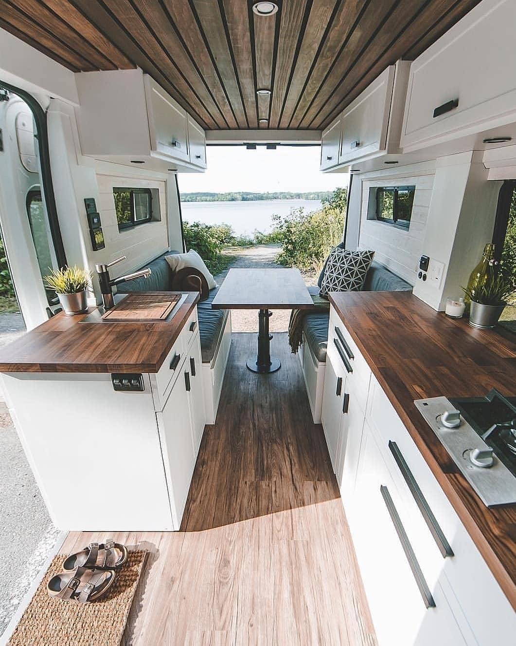 Van dining area with white cabinets and brown counters.Photo by Instagram user @vanlifevirals