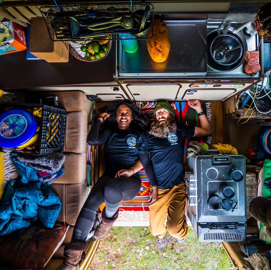 Couple laying on the floor of their small van. Photo by Instagram user @irietoaurora