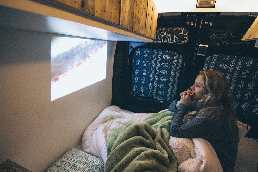 Girl watching TV with a projector and wall. Photo by Instagram user @repoweredram