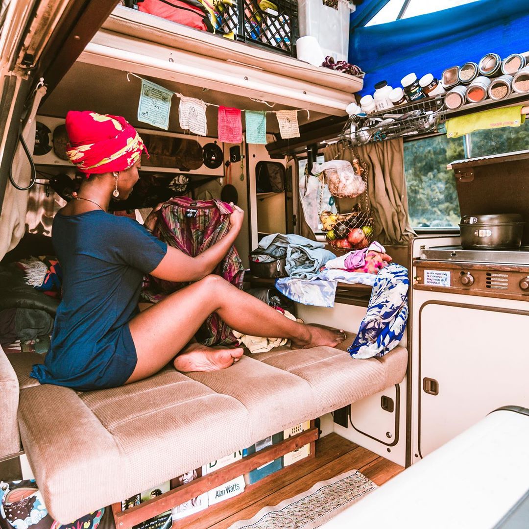 Woman folding her clothes in a van. Photo by Instagram user @irietoaurora