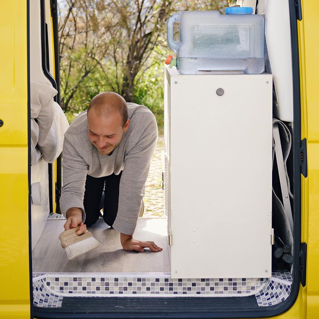 Guy cleaning the floor of van. Photo by Instagram user @ausgevandert