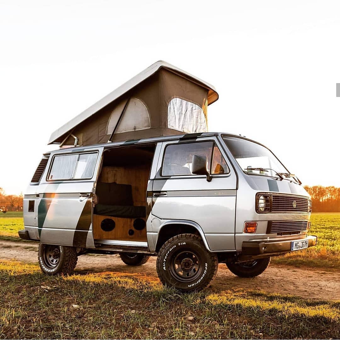 A Vanagon van with an open door in a field. Photo by Instagram user @vwt3spain