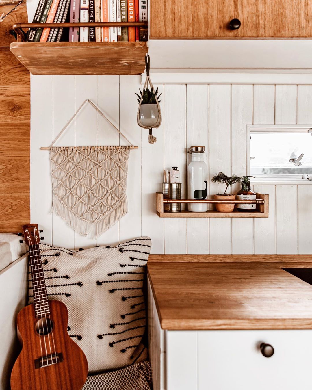 White wood walls with brown shelf. Photo by Instagram user @nomathehappyvan