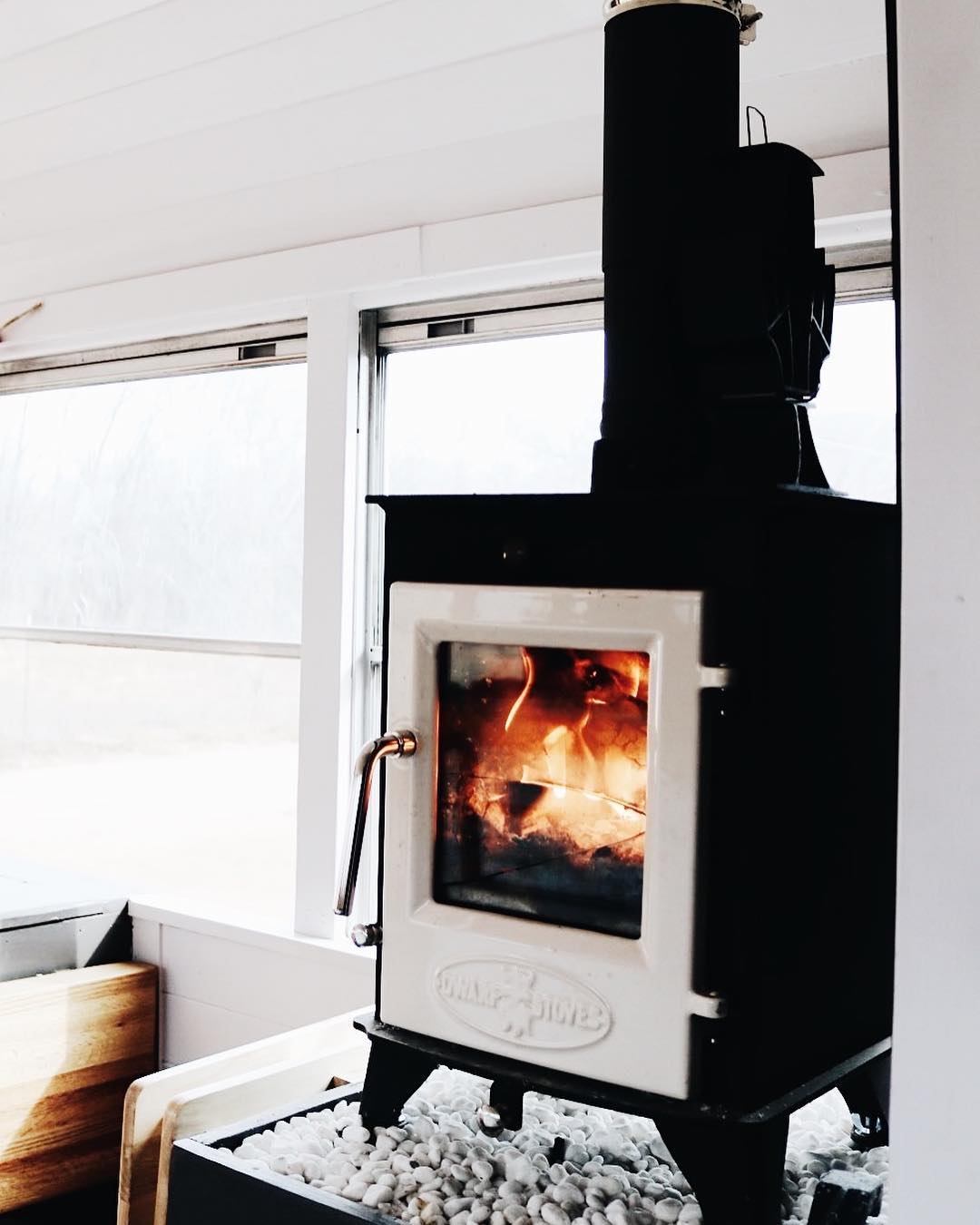 Black wood burning stove in a van. Photo by Instagram user @trebventure