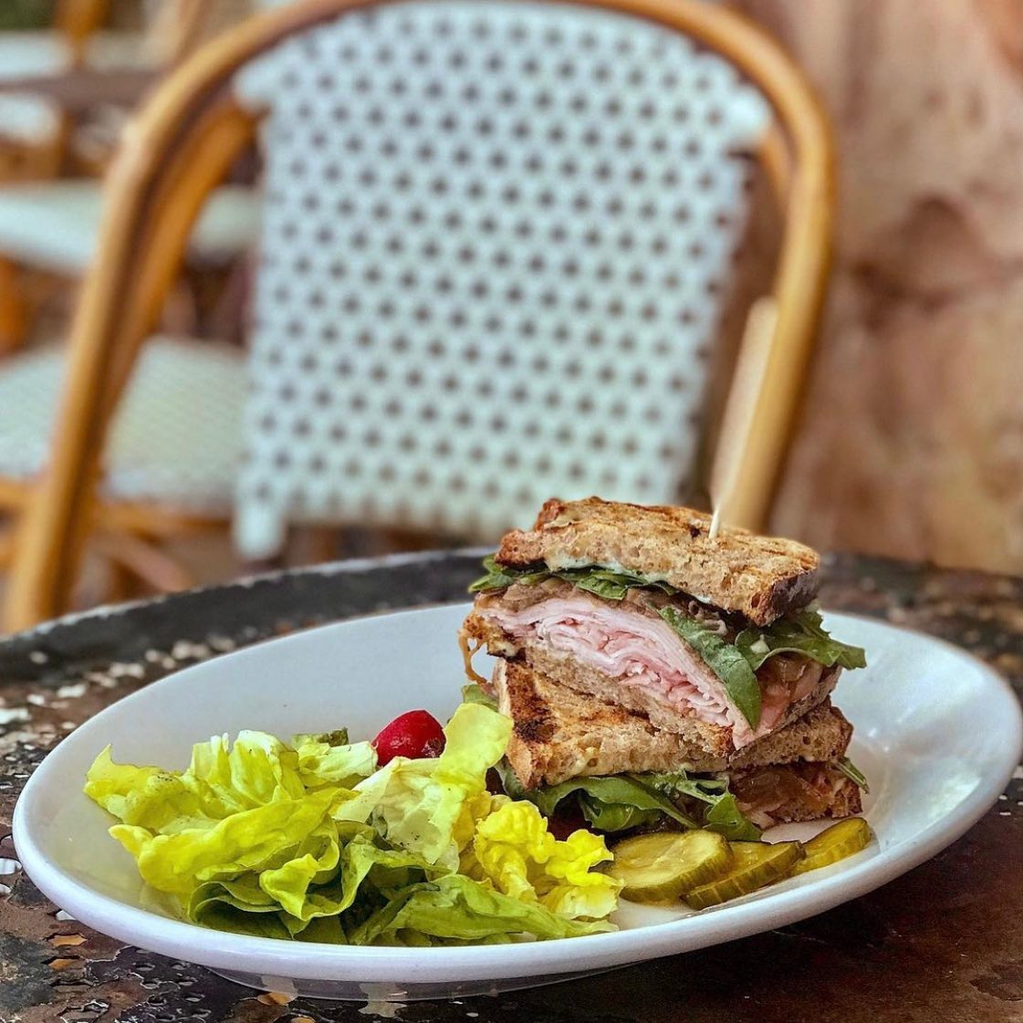 A turkey sandwich and a salad are pictured on a plate. Photo by Instagram user @fonfonbham
